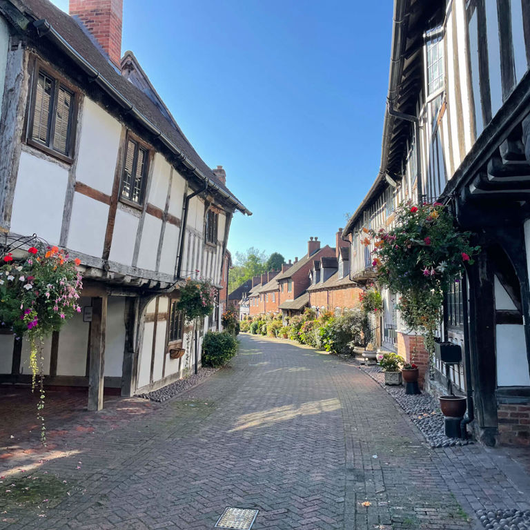 Narrow road with white and black houses on either side Narrow road with white and black houses on either side