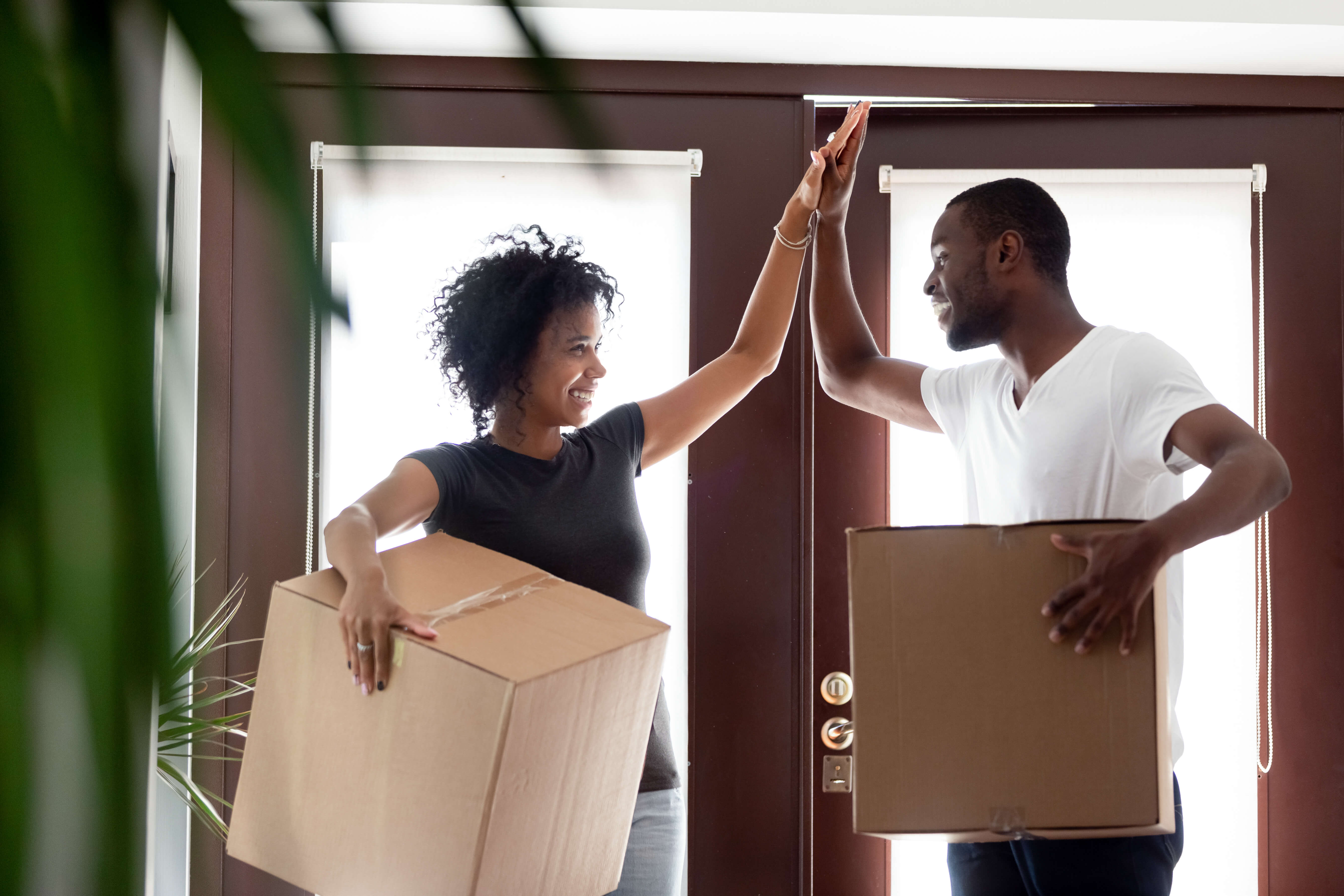 image of a man and a woman holding boxes and high fiving