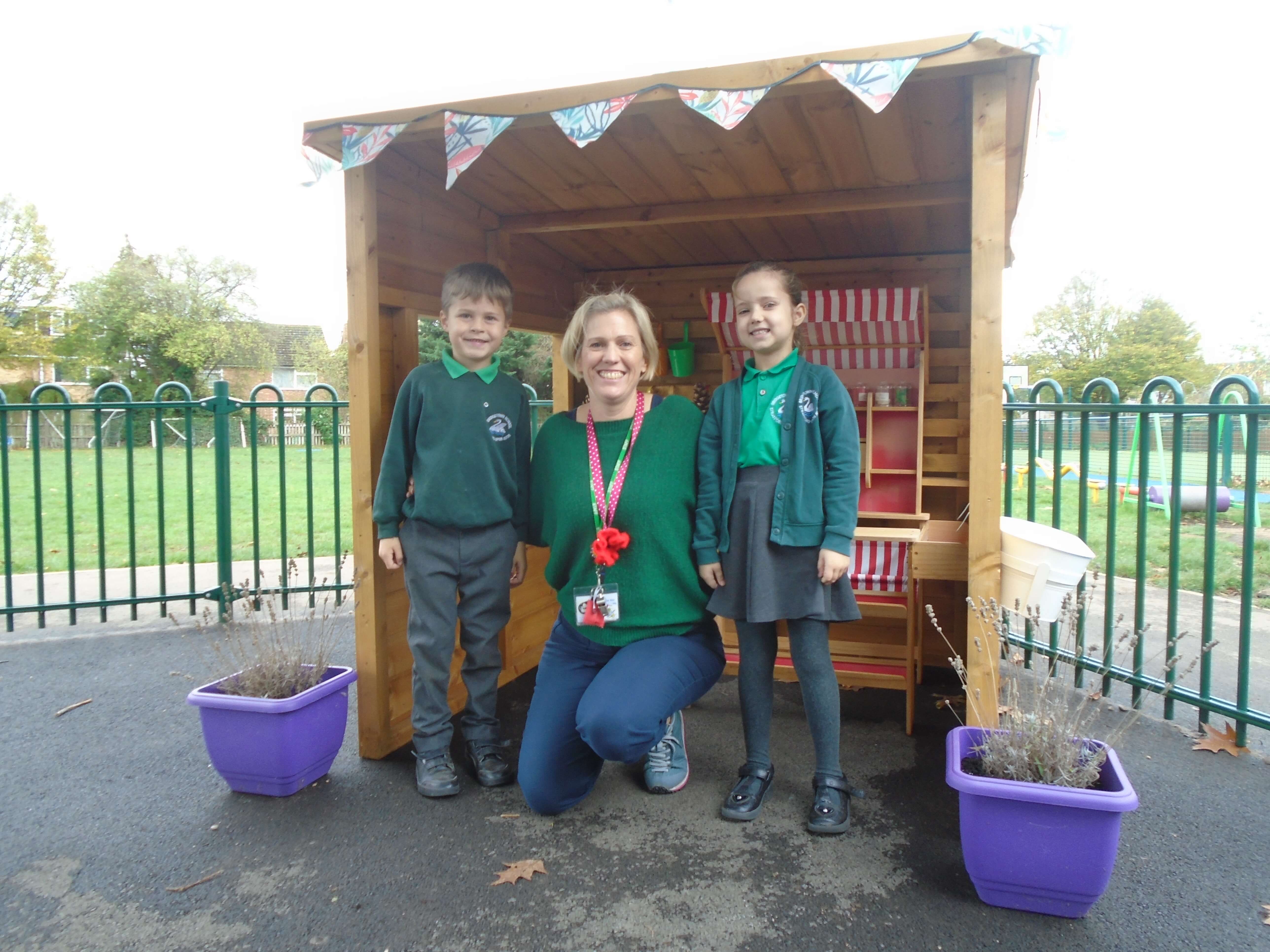 three children standing in a wooden shed three children standing in a wooden shed