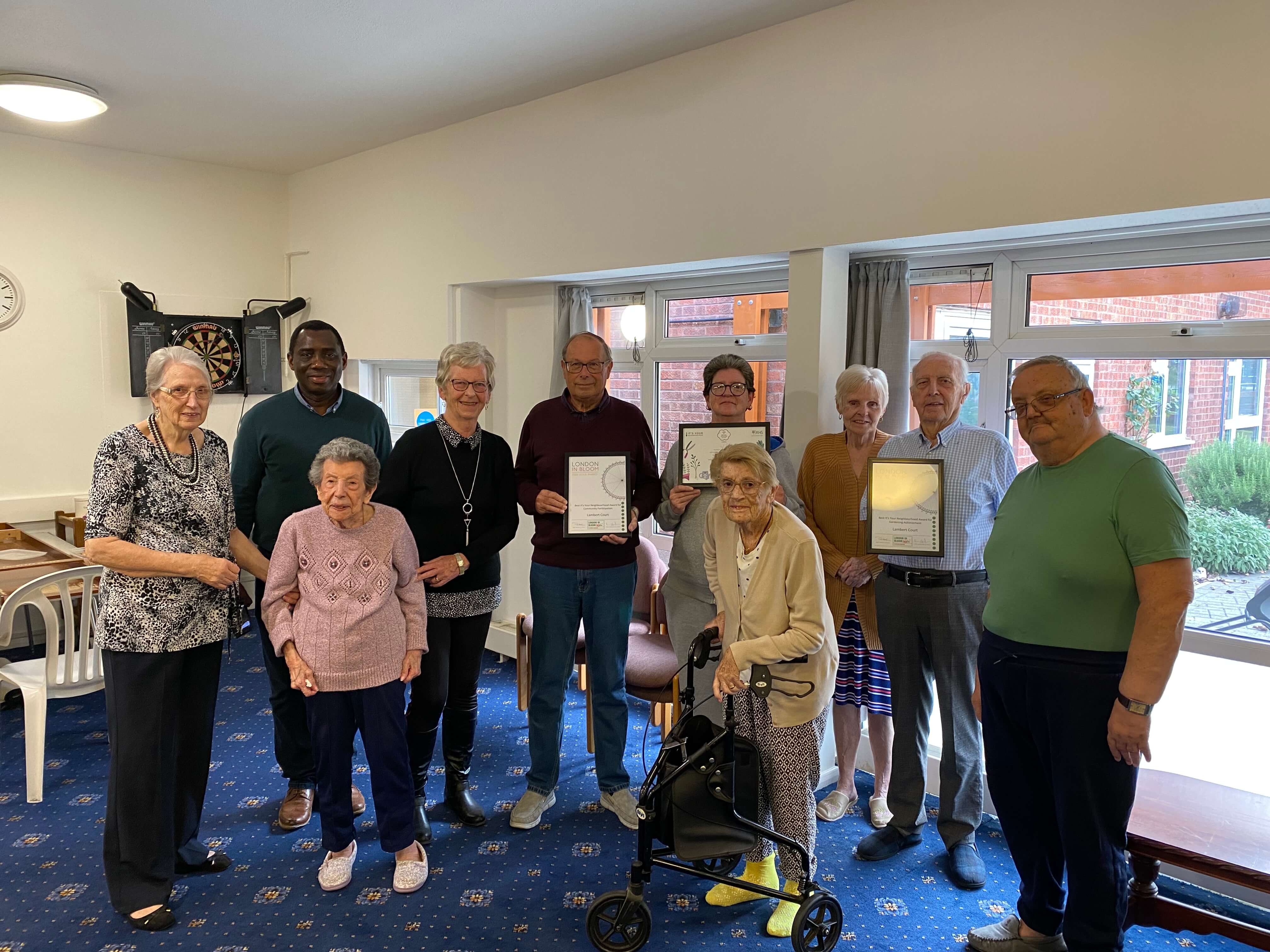 A group of people holding certificates for gardening awards A group of people holding certificates for gardening awards