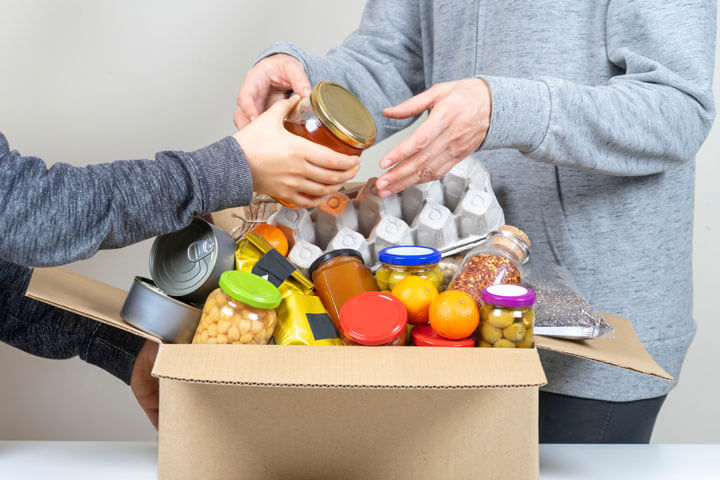 person passing a tin to another person person passing a tin to another person