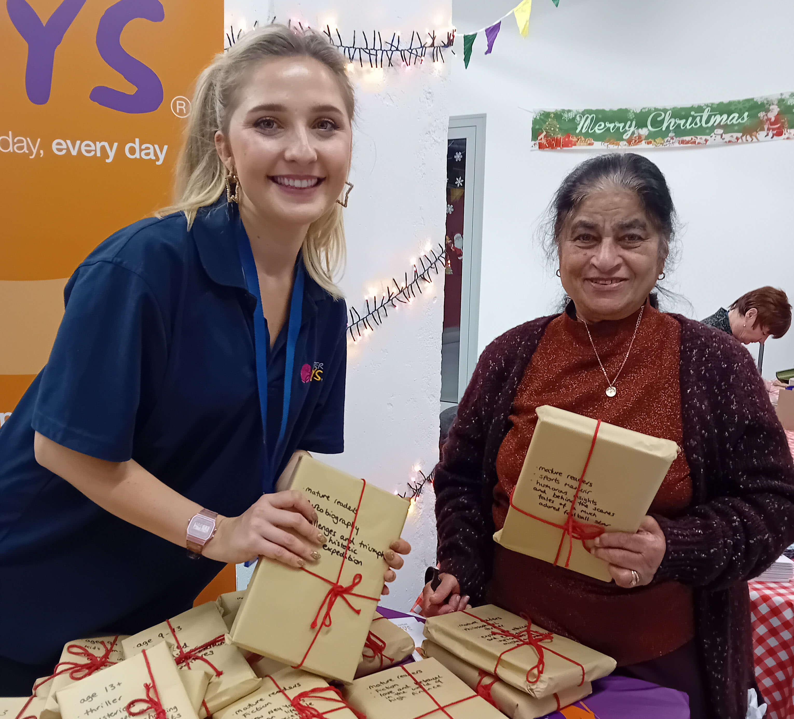 Two ladies holding wrapped gifts in brown paper and smiling Two ladies holding wrapped gifts in brown paper and smiling