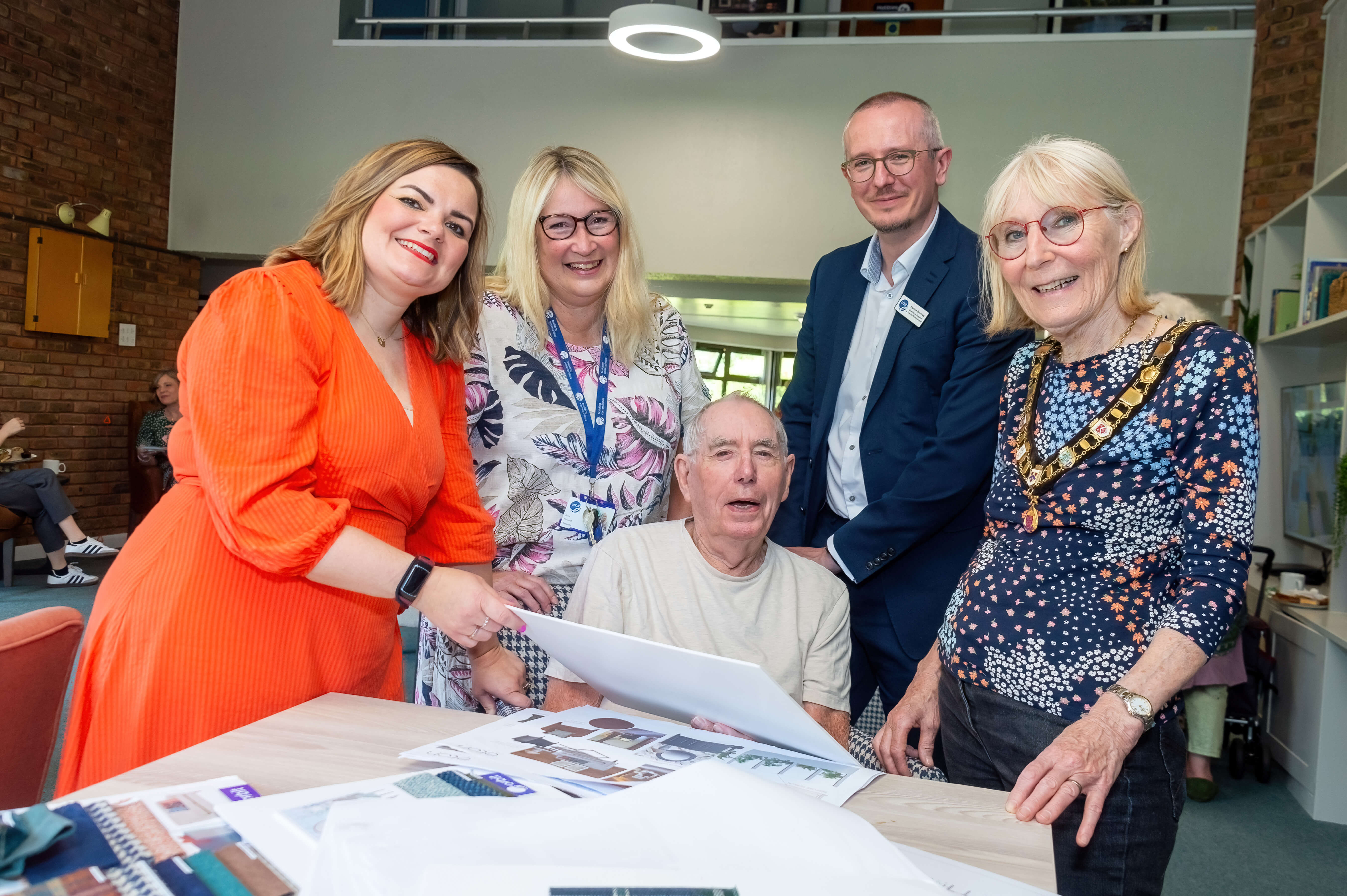 four people looking at designs