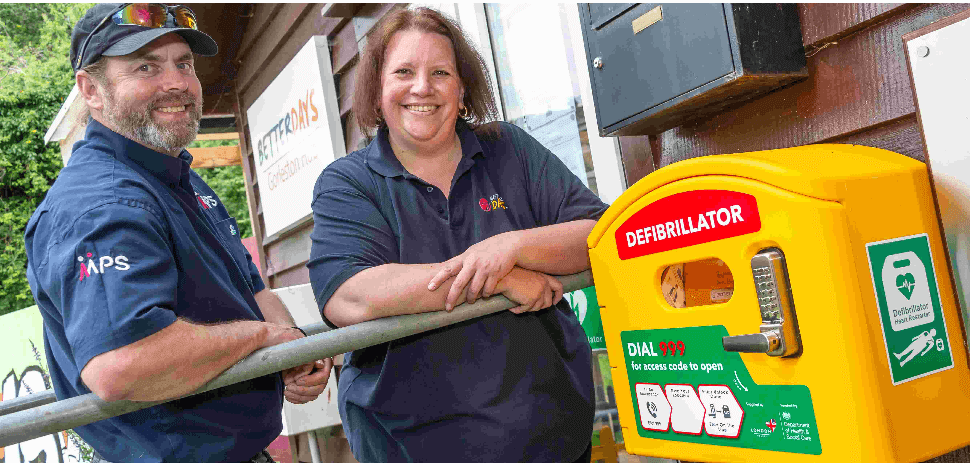 a man and woman standing next to a defibrillator