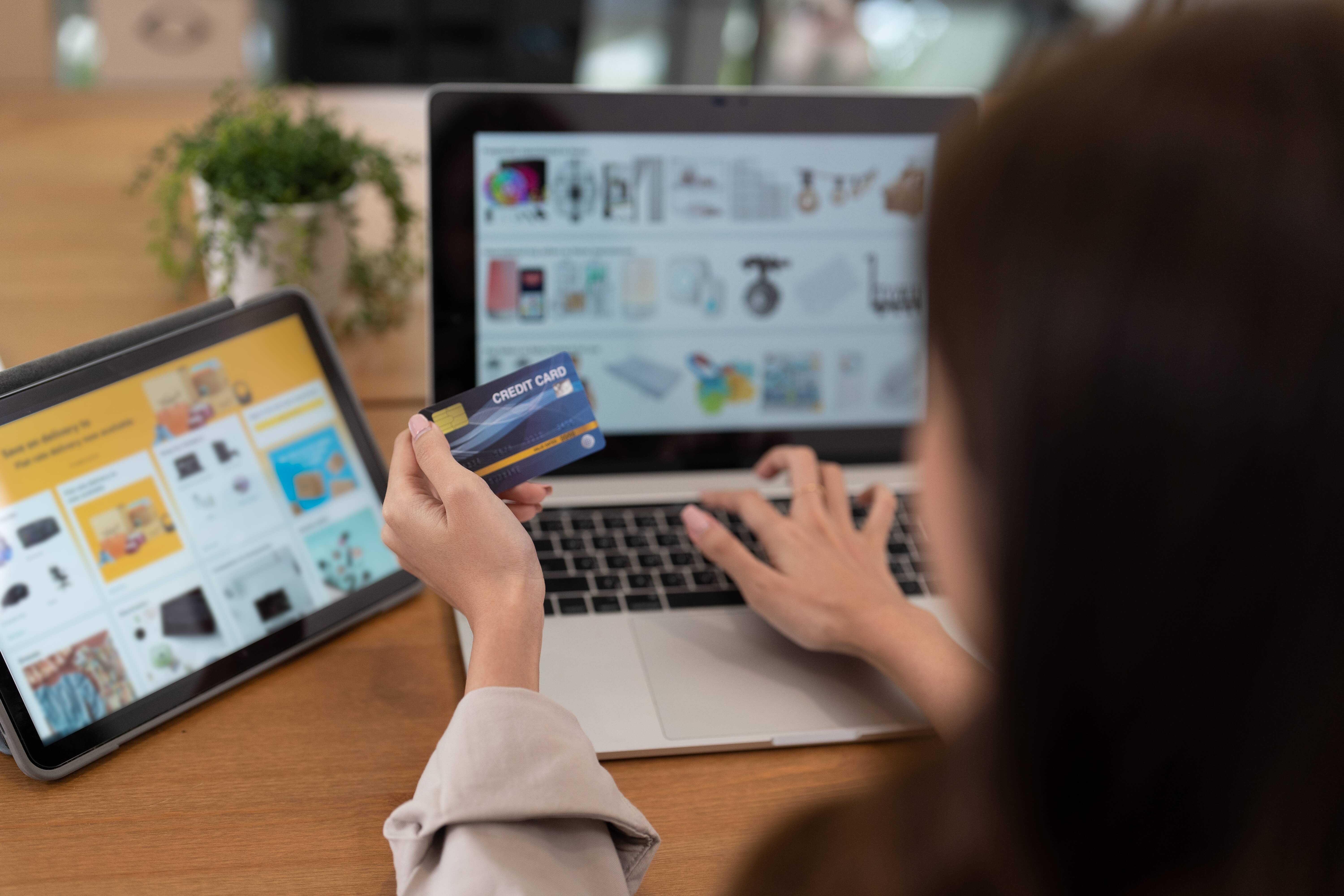 woman on laptop paying for items with bank card woman on laptop paying for items with bank card