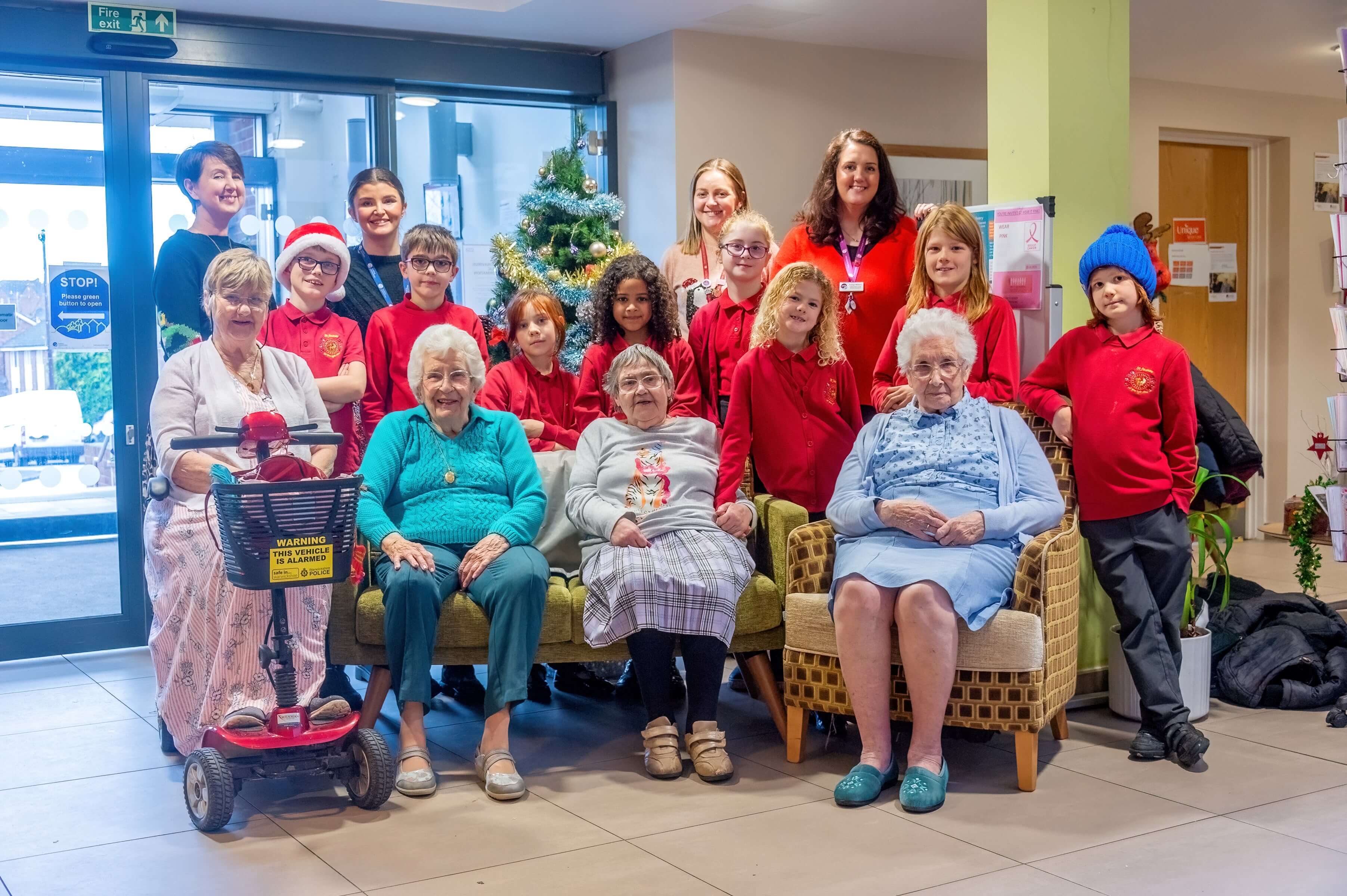 group of children from a choirs wearing red jerseys standing with older women group of children from a choirs wearing red jerseys standing with older women