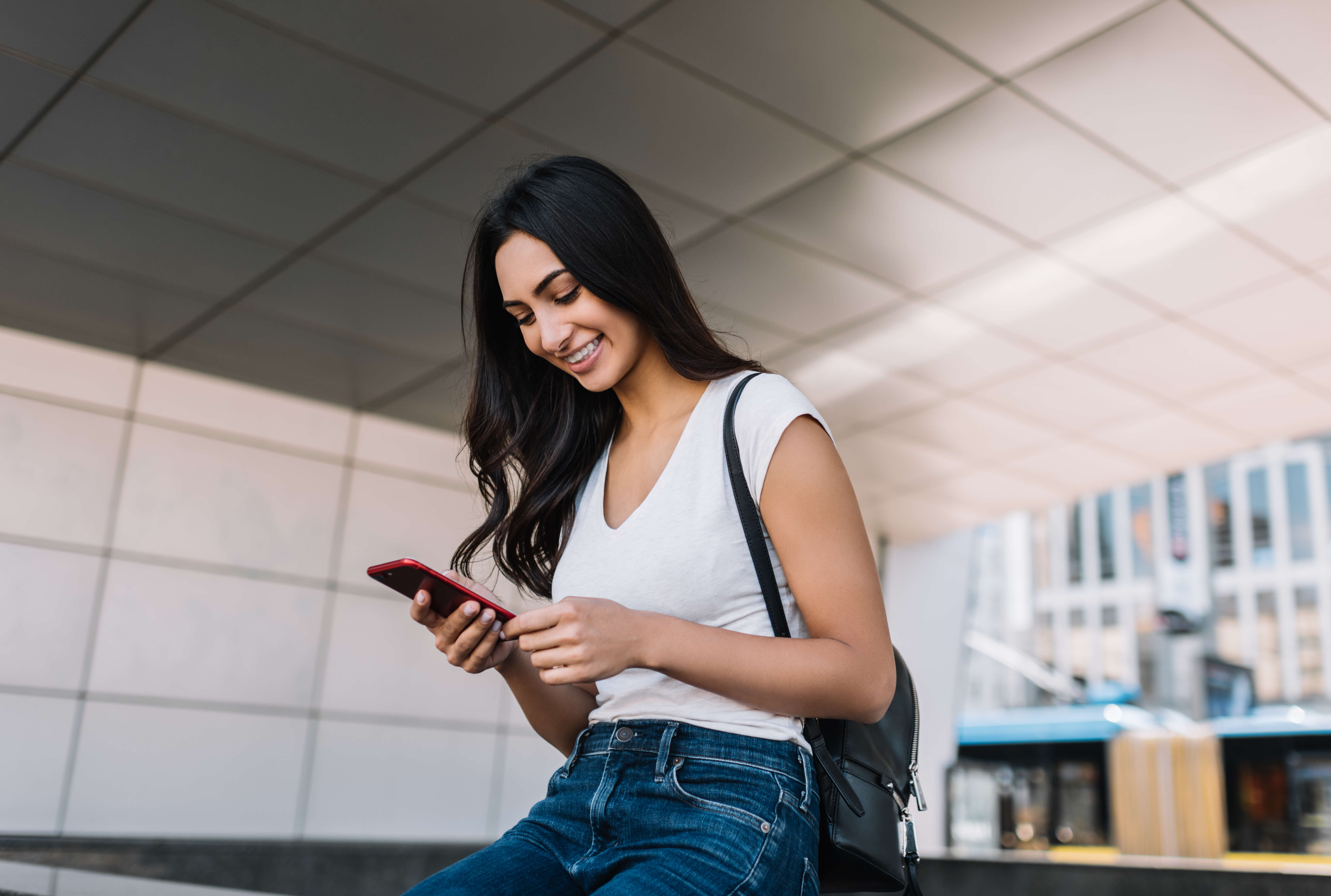 Woman smiling whilst looking at her mobile phone