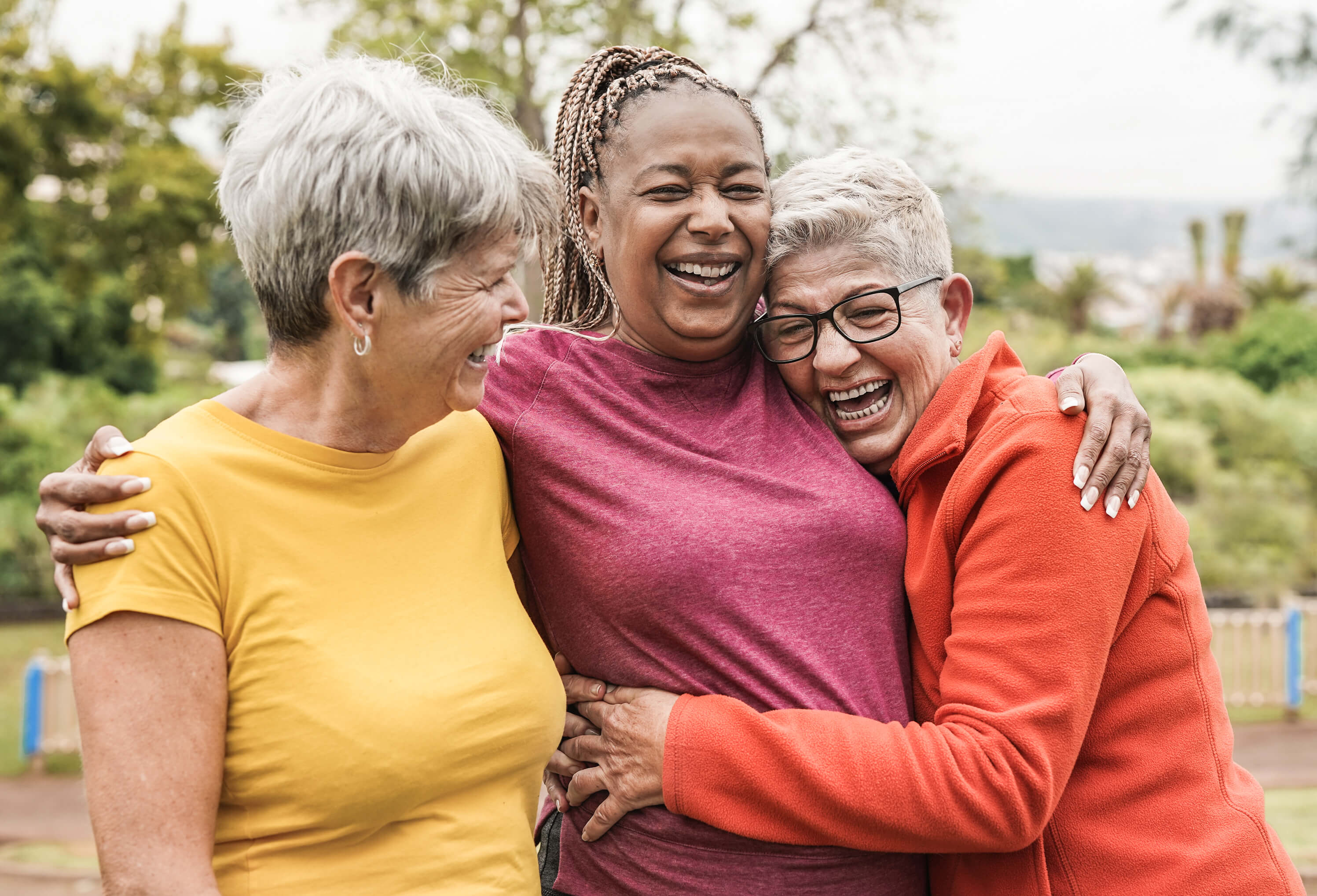 three women holding each other and laughing