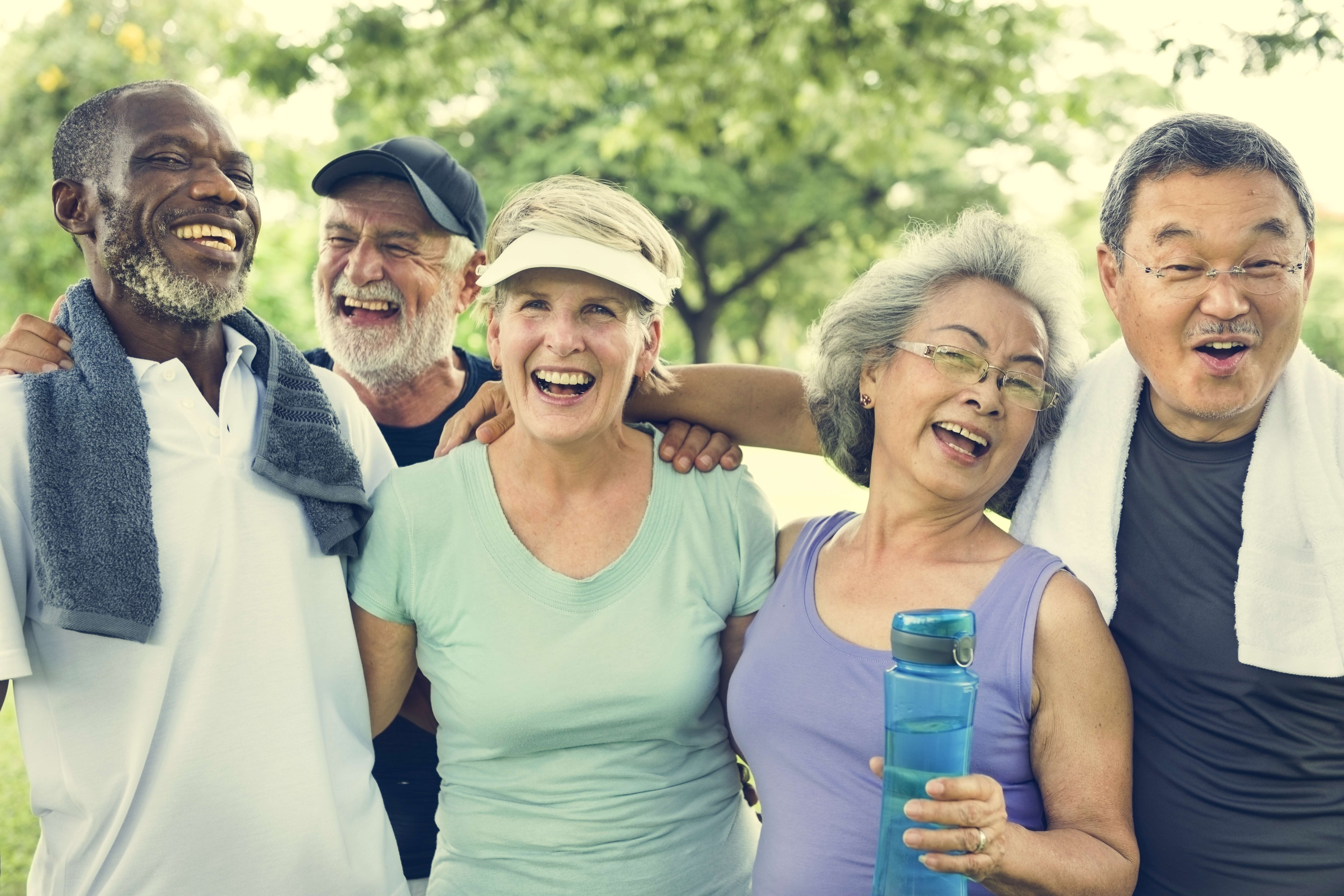 group of people with arms on each others shoulders laughing