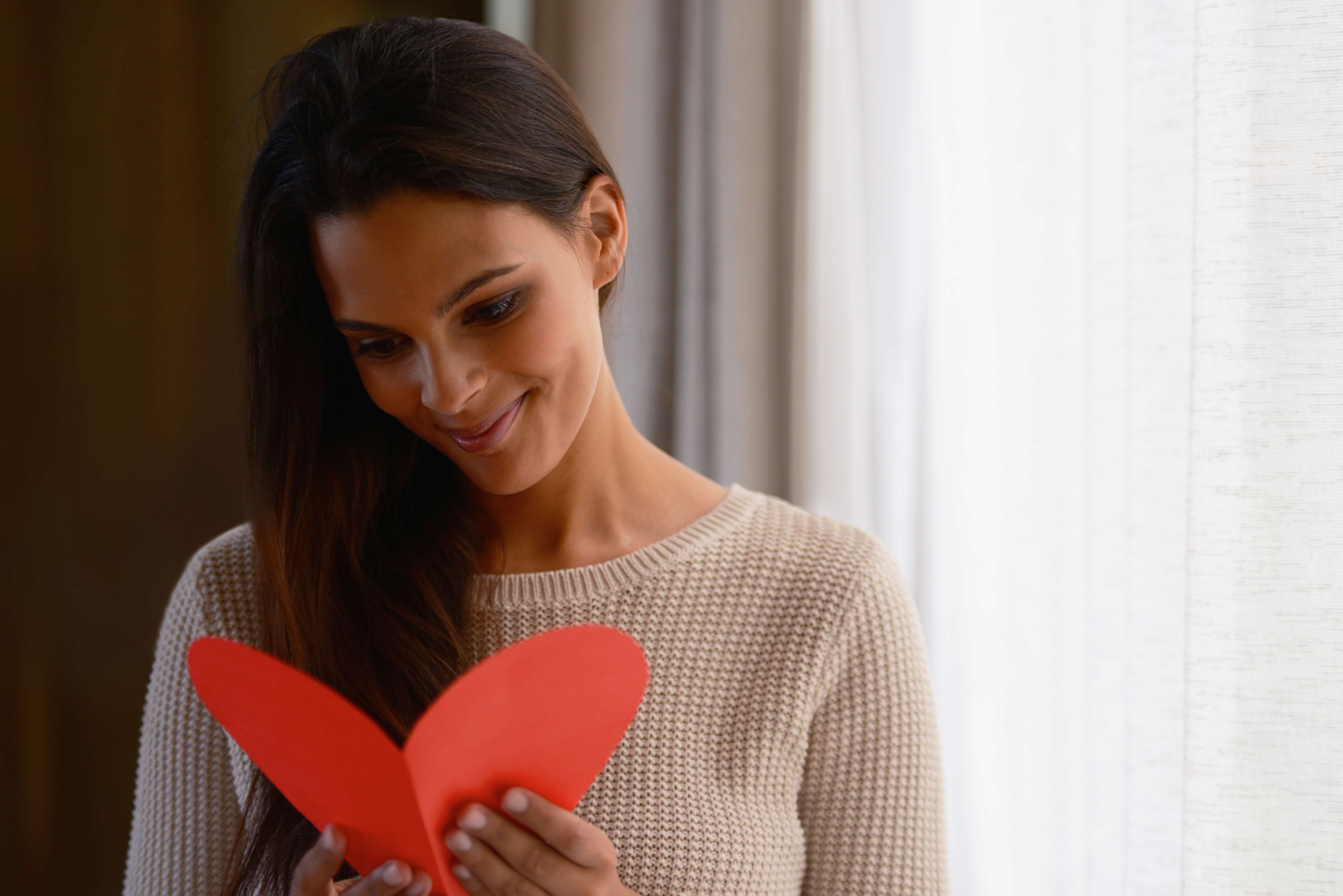 lady smiling and reading a heart card