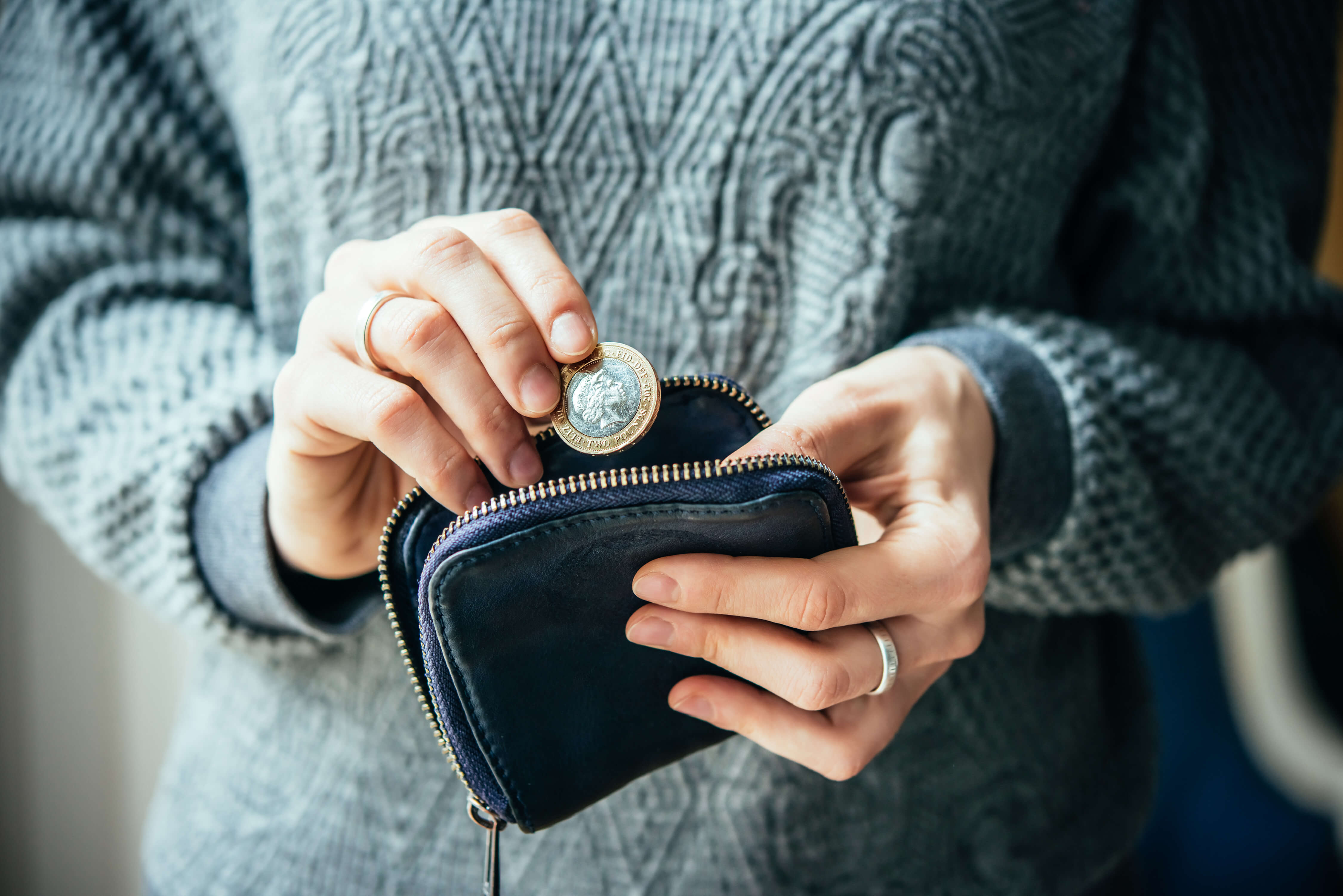 Woman putting a coin into a purse