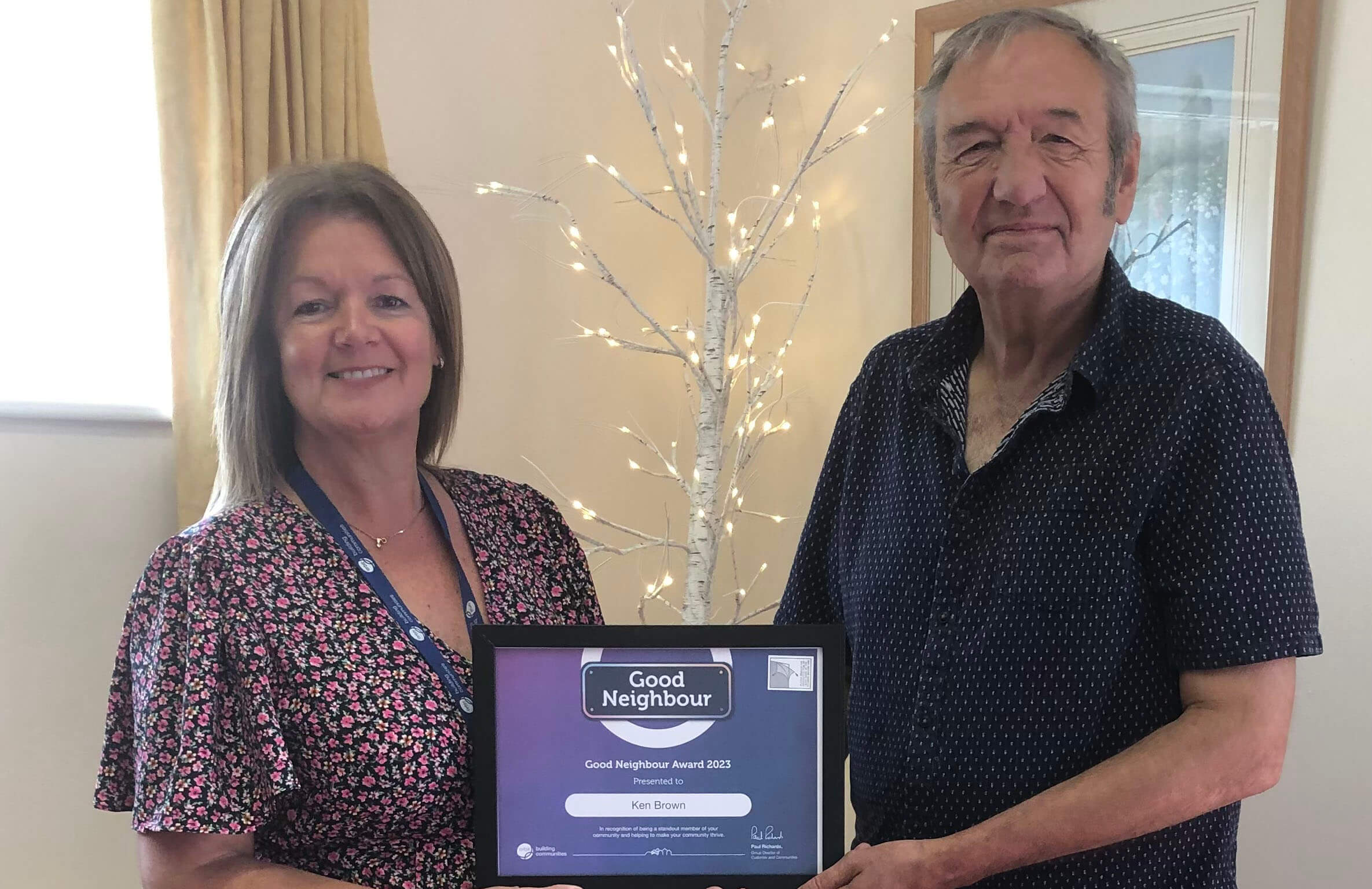 Man and lady standing holding a certificate